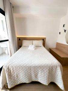 a bedroom with a bed with a white comforter at Blue Apto Automatizado Moderno in São Paulo