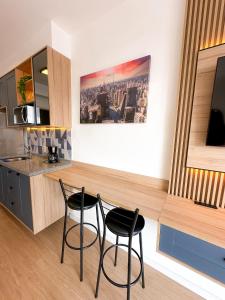 a kitchen with two black chairs and a counter at Blue Apto Automatizado Moderno in São Paulo