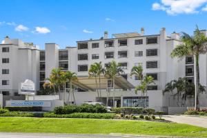 un edificio bianco con palme di fronte di Marcoola Beachside Resort a Marcoola