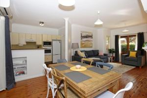 a kitchen and living room with a wooden table at Queen Street Cottage - By Berry Getaways in Berry