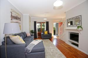 a living room with a couch and a fireplace at Queen Street Cottage - By Berry Getaways in Berry