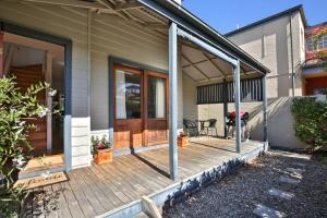 a front porch of a house with a wooden deck at Queen Street Cottage - By Berry Getaways in Berry