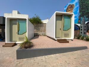 two modular homes are sitting in front of a wall at Villa Tiny- CÁPSULA FUTURÍSTICA in Ponta Grossa