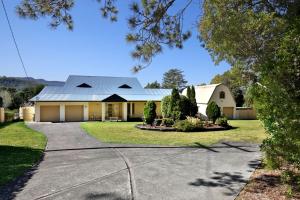 a house with a metal roof and a driveway at Floriel - By Berry Getaways in Berry