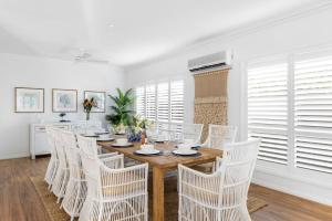 a dining room with a wooden table and white chairs at Berry Vista - By Berry Getaways in Berry