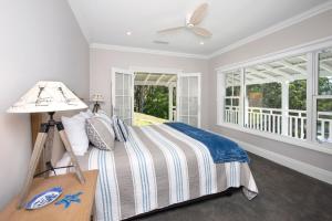 a bedroom with a bed and a ceiling fan at Possum Gully Lodge -By Berry Getaways in Berry