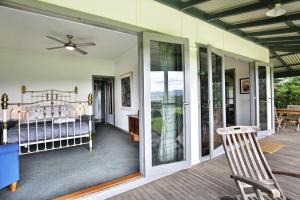a porch with a bed and sliding glass doors at Borrowdale - By Berry Getaways in Berry