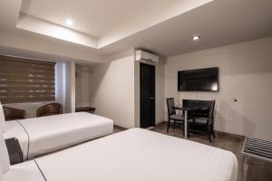Postel nebo postele na pokoji v ubytování Hotel Astor Tijuana