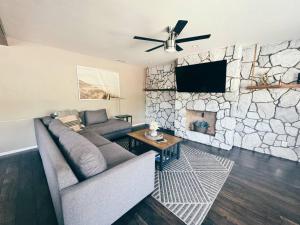 a living room with a couch and a stone fireplace at Spacious & Immaculate Haven near Downtown SD in San Diego