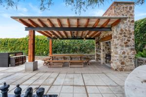 an outdoor patio with a wooden pergola and picnic tables at Cabañas Xidó San Miguel in San Miguel de Allende