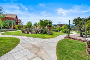 a walkway in a yard with grass and trees at Cabañas Xidó San Miguel in San Miguel de Allende