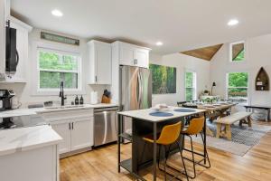 a kitchen with white cabinets and a table with chairs at White Pines Lodge- Wooded Retreat in Cub Run +40 photos
