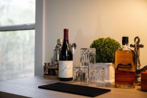 two bottles of wine and a glass on a counter at White Pines Lodge- Wooded Retreat in Cub Run