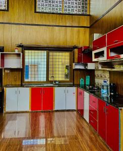 a large kitchen with red and white cabinets at Luxury patriata house murree in Patriata