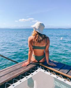 a woman in a bikini sitting on the deck of a boat at Sol Bungalows Bocas del Toro in Bocas del Toro