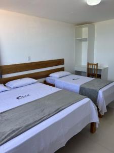 a bedroom with two beds and a mirror at Hotel Beira do Rio in Ibotirama +11 photos