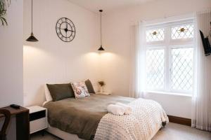 a bedroom with a bed and a clock on the wall at Harmony House - CBD in Launceston