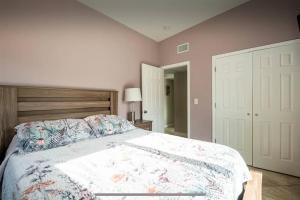 a bedroom with a bed with a floral bedspread at Coral Cottage Pool & Beach & Golf in Cocoa Beach +34 photos