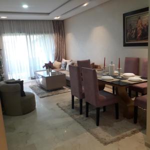 Un comedor y una sala de estar con mesa y sillas. en Marrakech al hamraa, en Marrakech