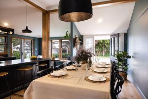 a dining room with a long table and chairs at Mabel's Cottage - By Berry Getaways in Berry