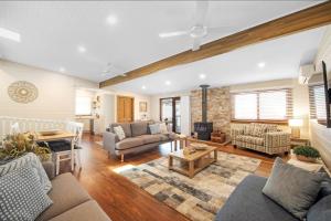 a living room with a couch and a table at Rosemill Cottage - By Berry Getaways in Berry