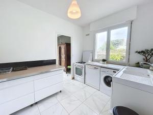 a large white kitchen with a washer and dryer at Maison calme, proche plage et commerces à Jullouville, jardin clos, 3 chambres, idéale vacances - FR-1-361-381 in Jullouville-les-Pins