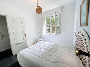 a white bedroom with a bed and a window at Maison calme, proche plage et commerces à Jullouville, jardin clos, 3 chambres, idéale vacances - FR-1-361-381 in Jullouville-les-Pins