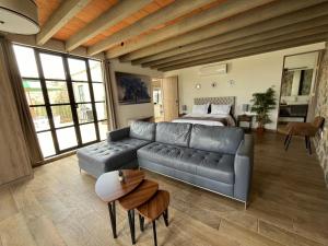 a living room with a leather couch and a bed at Casa Frida con Piscina Privada Caliente, Aire Acondicionado, Billar, Parrilla & FirePit in San Miguel de Allende