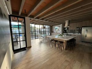a kitchen with a table and chairs and a refrigerator at Casa Frida con Piscina Privada Caliente, Aire Acondicionado, Billar, Parrilla & FirePit in San Miguel de Allende