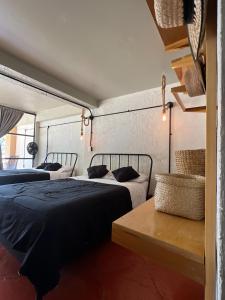 a bedroom with two beds and a table with a bench at Los Cruxes Sam Paz in Tepoztlán +31 photos