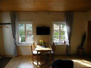 ein Esszimmer mit einem Tisch und 2 Fenstern in der Unterkunft Weingut Koch in Neumagen-Dhron