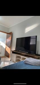 a bedroom with a large flat screen tv on a entertainment center at Condomínio paixão 4 in Aparecida