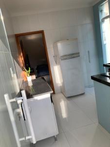 a small kitchen with a refrigerator and a sink at Condomínio paixão 4 in Aparecida +2 photos