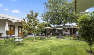 a yard with chairs and tables and umbrellas at Hotel Casona El Calvario in Huichapan +70 photos