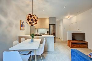 a kitchen and dining room with a white table and chairs at Jolie Condo Great Location 2BD presented by TripMontreal I in Montreal +1 photo