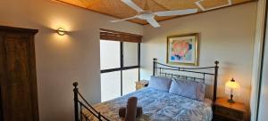 Schlafzimmer mit einem Bett, einem Deckenventilator und einem Fenster in der Unterkunft Riverview Holiday Apartment 15 - Kalbarri, WA in Kalbarri