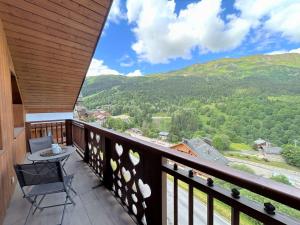 a balcony with a chair and a view of the mountains at Appartement 5 pièces avec balcon et garage à Méribel - FR-1-180-624 in Les Allues