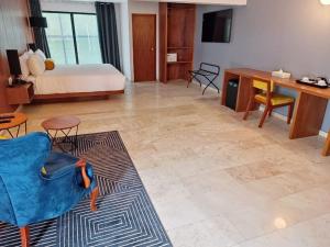 een woonkamer met een bed en een blauwe stoel bij HOTEL LUCA in Mexico-Stad