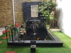 Un estanque de koi en un jardín con una fuente. en homestay serayu cluster, en Wonosobo