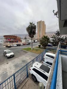 two white cars parked next to a blue fence at Hermoso apartamento a pasos de la playa in Iquique