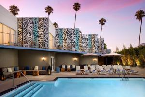 un complejo con piscina y un edificio con palmeras en Hyatt Centric Delfina Santa Monica, en Los Ángeles