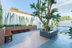 eine Terrasse mit einer Bank und einem Baum und einem Pool in der Unterkunft Villa 50M To Beach - Room Karaoke Free in Vũng Tàu