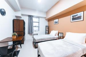 a hotel room with two beds and a desk at The City Flats Circuit in Manila +25 photos