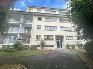 カーンにあるDuplex familial et confortable proche Zénithの駐車場付きの白い大きなアパートメントです。