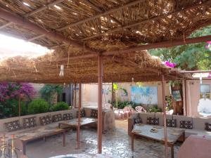 un patio con panchine e tetto di paglia di "Par 4 Chemins" - Atypical stopover a Nouakchott
