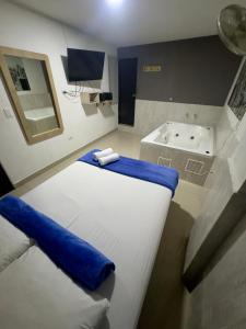 a room with a bed and a bath tub at Hotel Select Medellin in Medellín