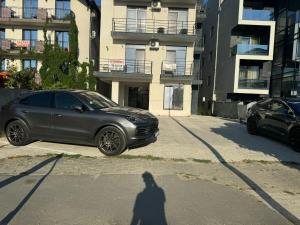 a shadow of a person standing in front of a car at Mihail apartments in Năvodari