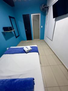 a bedroom with two beds and blue walls at Hotel Select Medellin in Medellín +68 photos