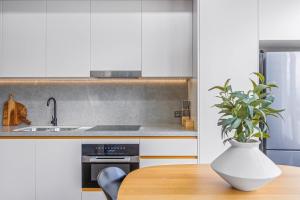 a kitchen with a table and a vase with a plant at Executive Beachside Getaway in Maroochydore