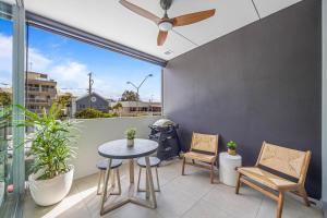 a patio with a table and chairs on a balcony at Executive Beachside Getaways in Maroochydore